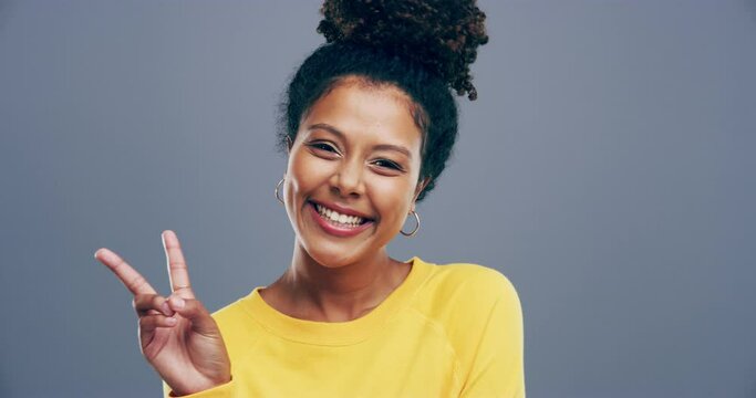 Happy, face and black woman with hands for peace, sign or freedom emoji in gray background, studio or mockup. V, symbol and person gesture for kindness with smile, finger icon and profile picture