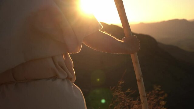 A Bible prophet holding his staff on a mountain top at sunset