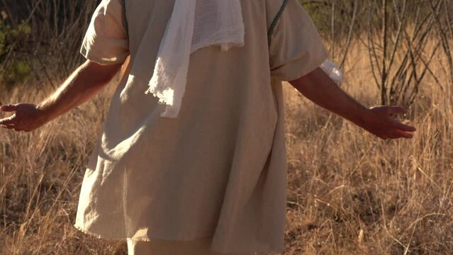 A Bible prophet or holy man walking with hands out in prayer