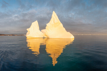 Arctic nature landscape with icebergs in Greenland icefjord with midnight sun. Early morning summer...