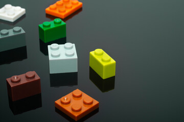 Multi-colored plastic children's construction blocks on a black background.