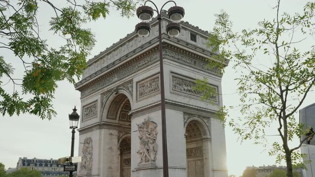 Vista del Arco del triunfo tras una farola y ramas de arboles en la ciudad de París