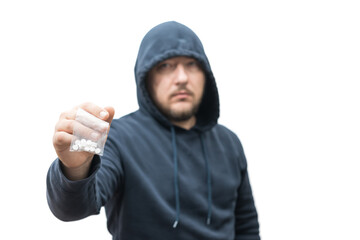 Criminal man in a hood holds transparent plastic bag with pills hard drugs isolated on white...