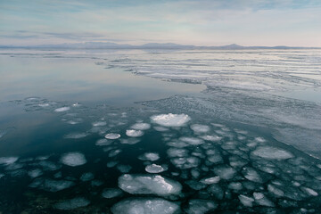 Sea winter landscape. Sea slush and ice floes on the sea surface in winter during sunset. Fabulous...