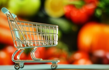 carro de la compra con productos fruticolas de fondo