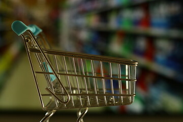 carro de la compra con fondo de supermercado desenfocado.