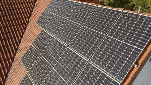Photovoltaic solar modules installed on the tiled roof of a private house. A household power supply system powered by solar energy for the electrification of private homes.