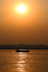 The sun rises over the eastern riverbank of the Ganges River near Varanasi India.
