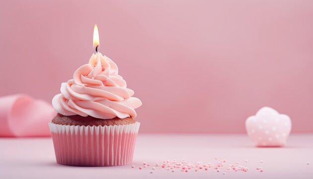 Birthday cupcake with pink candle on light pink background, perfect for joyous celebrations