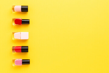 Nail polishes on yellow background. Beauty background