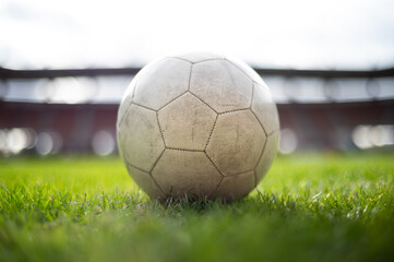 White soccer ball lying on the grass at stadium