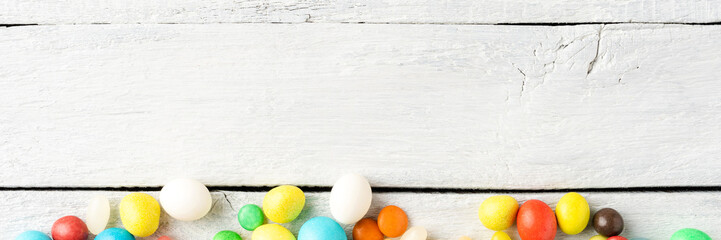 Mixed colourful candies on white wooden background with copyspace