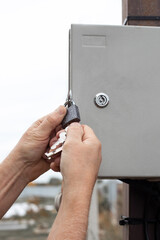 An electrician locks an electrical panel with automatic switches. Supplying electricity to the...