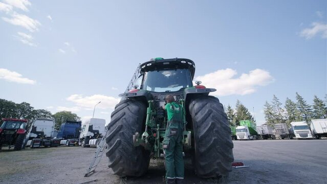 Farmer mechanic repairing tractor. Open tractor hood, engine. Repair agricultural technology