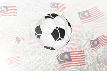 National Football team of Malaysia scored goal. Ball in goal net, while football supporters are waving the Malaysia flag in the background.