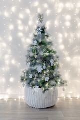 A Christmas tree decorated with white decor