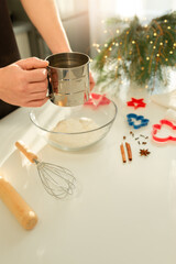 Male hands sifting flour for Christmas cookie recipe
