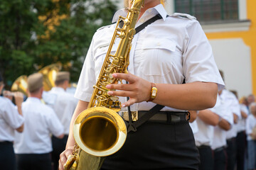 Military musician with a saxophone in her hand - obrazy, fototapety, plakaty