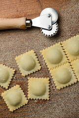 Ravioles frescos cortados a mano con cortapasta de rueda dentada rellenos de espinaca y pollo o...