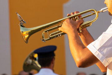 Military musician plays trumpets at a festival