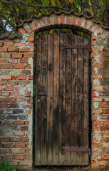Old wooden door in brick wall in autumn fresh day in Bludov town