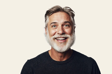 Fototapeta premium Joyful middle-aged man with salt and pepper beard, smiling on a white background.