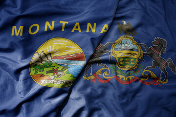 big waving colorful national flag of pennsylvania state and flag of montana state .