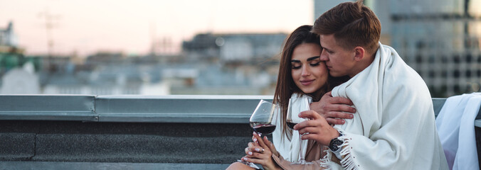 Beautiful young loving couple on a surprise romantic date on a roof top. Picturesque view,...