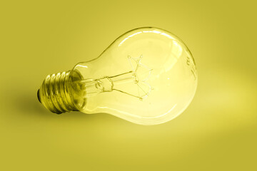 old tungsten filament incandescent bulb on yellow tone background