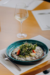 Beef carpaccio with pesto sauce and parmigiano cheese decorated by salad and fruit. Restaurant menu
