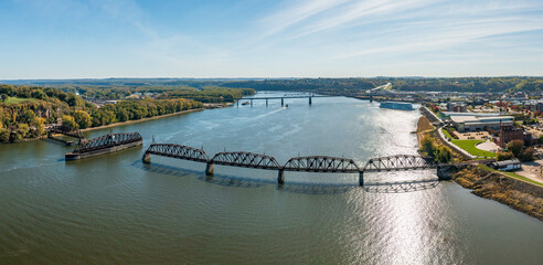 Aerial view of historic Dubuque railroad bridge between Iowa and Illinois across the Mississippi river with cruise boat in distance