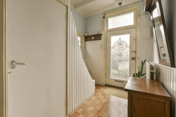 Fototapeta na wymiar a hallway in a house with wood flooring and white trim on the walls, door is open to another room