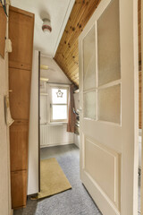 the inside of an rv with wood paneling on the walls, and carpeted area in front of the door