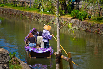People in a boat over tha canal in japan
