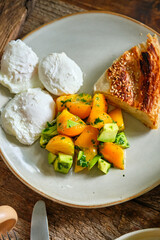 Breakfast. Turkish puff pastry, salad of yellow tomatoes, avocado, poached egg. White sauce