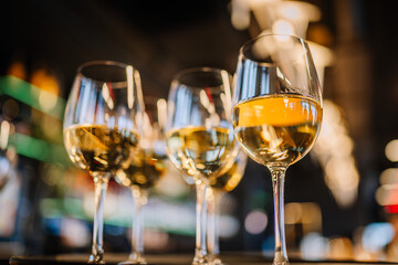 Glasses with wine and champagne on a bright golden expensive glowing background horizontal
