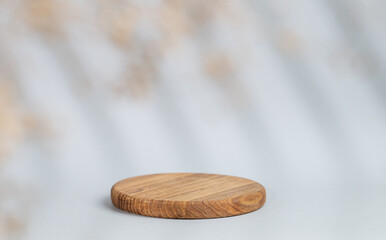 Abstract empty wooden board with shadows leaves on a gray background. Layout concept for promotional product presentation, sale or cosmetics display.