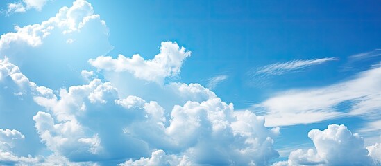 The background of the sky in the summer is filled with the mesmerizing beauty of nature as the light illuminates the white clouds against the vibrant blue color creating a stunning and natu