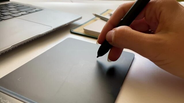 Close-up of a hand working with a pencil for a graphics tablet