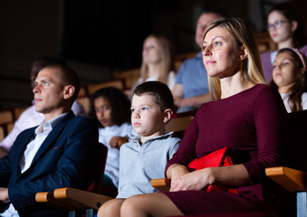 caucasian family sitting at premiere in theatrical hall - obrazy, fototapety, plakaty