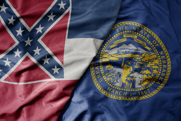 big waving colorful national flag of nebraska state and flag of mississippi state .