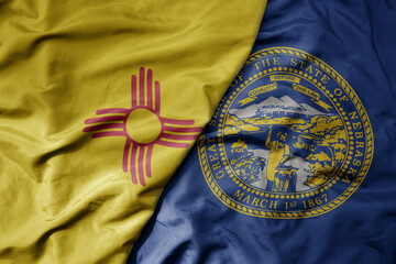 big waving colorful national flag of nebraska state and flag of new mexico state .