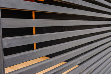 The beige wood fence texture on the horizontal wooden house wall creates a charming pattern with inviting spaces.