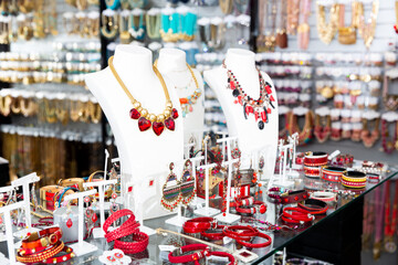 Collection of stylish bijouterie displayed for sale on shelves of costume jewelry boutique