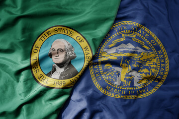 big waving colorful national flag of nebraska state and flag of washington state .