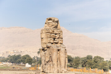 Massive ruined stone Pharaoh statues at Colossi of Memnon in Luxor, Egypt