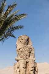 Massive ruined stone Pharaoh statues at Colossi of Memnon in Luxor, Egypt