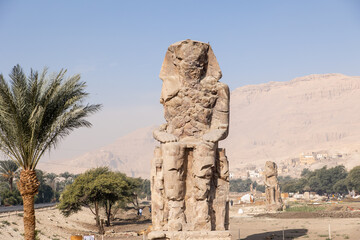 Massive ruined stone Pharaoh statues at Colossi of Memnon in Luxor, Egypt