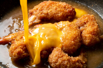 揚げ物残り物リメイク。だし汁で煮たエビフライに溶き卵を加え、卵とじする調理シーン。
