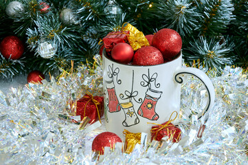 Christmas background with beautiful mug with gifts and balls in beautiful tinsel